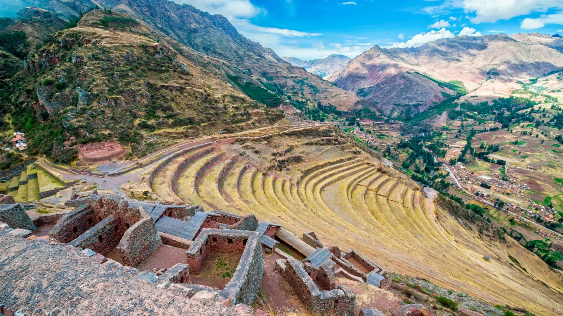 Vista aérea de las terrazas circulares de Pisaq, con el valle y el pueblo al fondo.